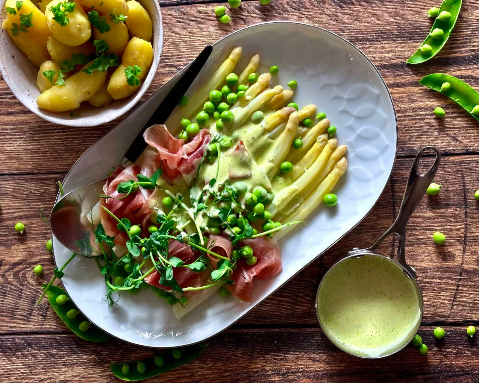 Hvide asparges med skinke, ærter og sauce blanquette