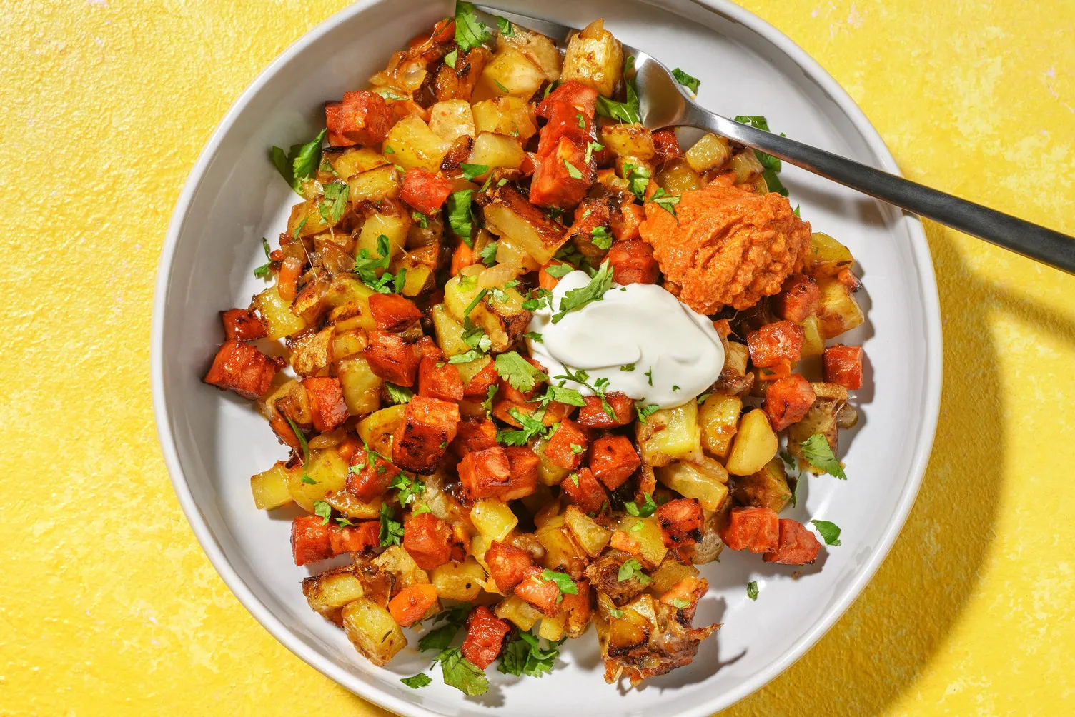 Hurtig chorizo- og kartoffel-cowboypande med revet ost, fraiche og calabresepesto