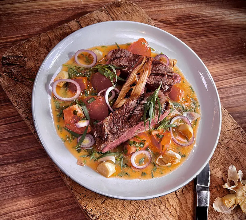 Grillet ribeye på tomat-estragonsmørsauce med bagte hvidløg og grillet skalotteløg