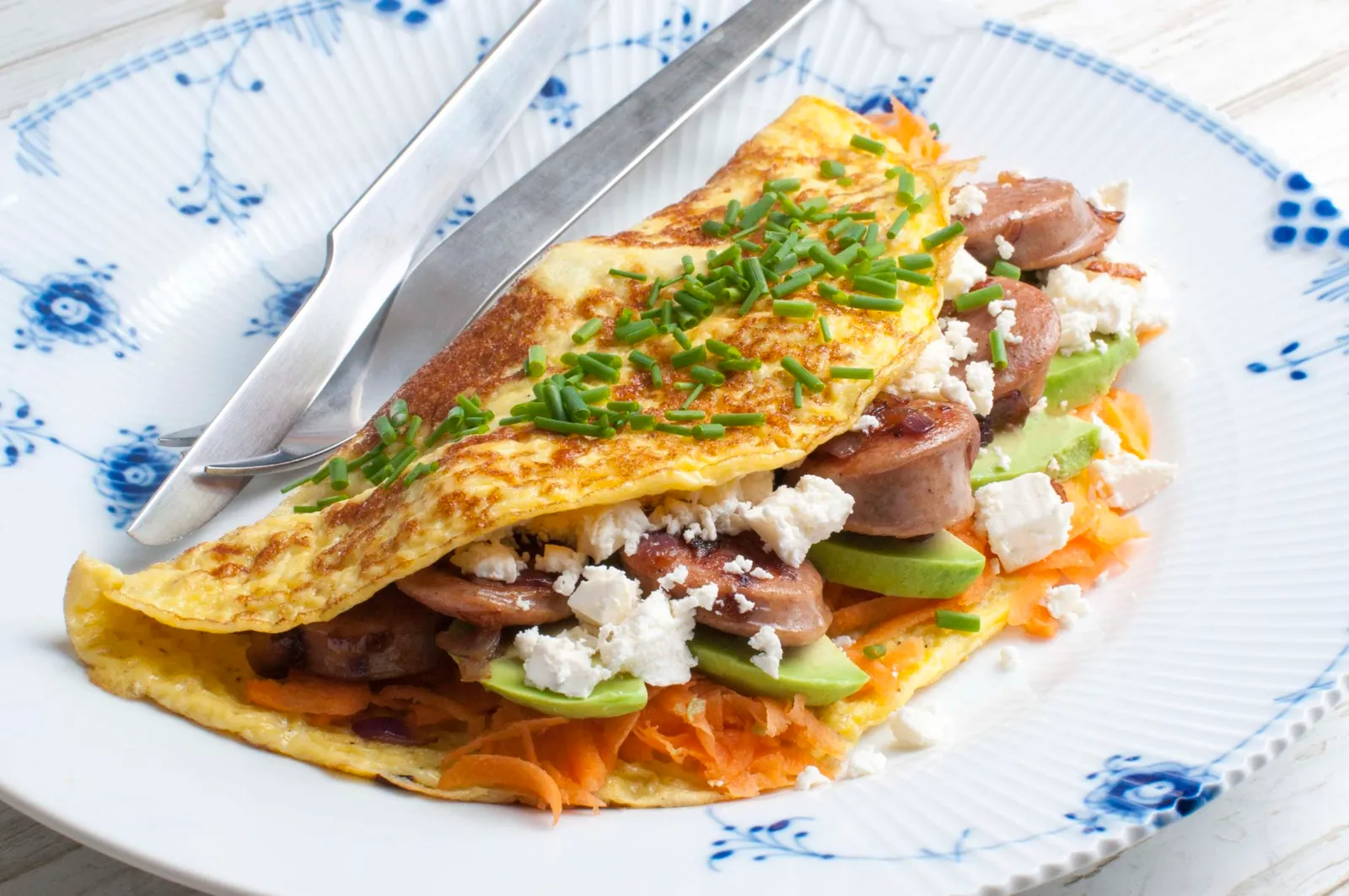 Omelet med pølse, avocado og salatost